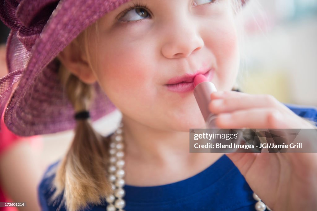 Girl playing dress up with lipstick