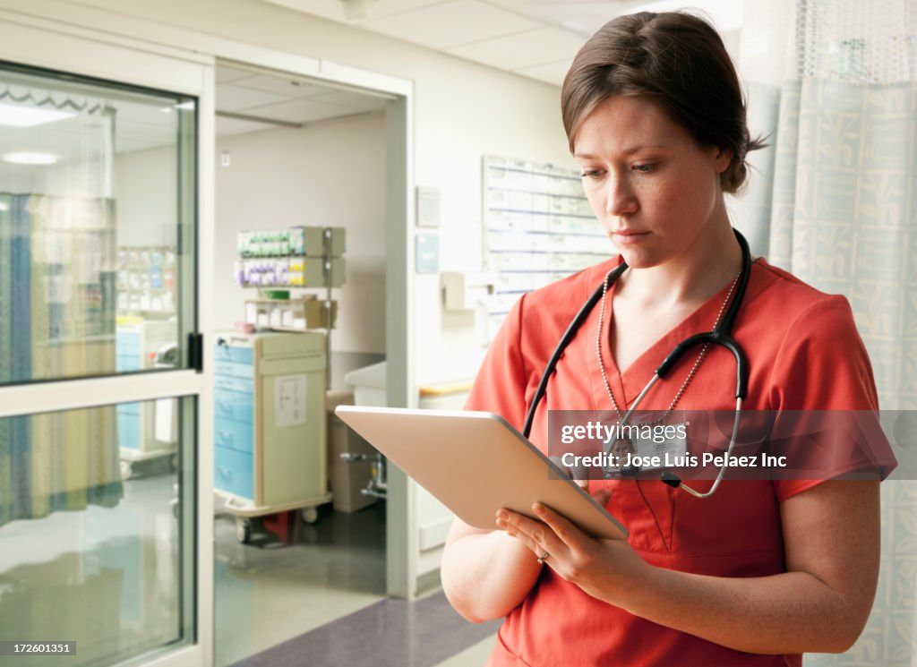 Caucasian nurse using tablet computer