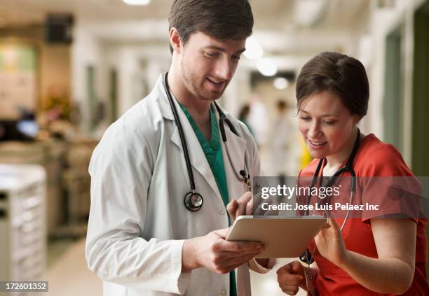 caucasian doctor and nurse using tablet computer - healthcare tablet image focus technique stock pictures, royalty-free photos & images