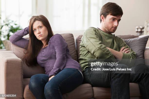 caucasian couple arguing on sofa - debate fotografías e imágenes de stock