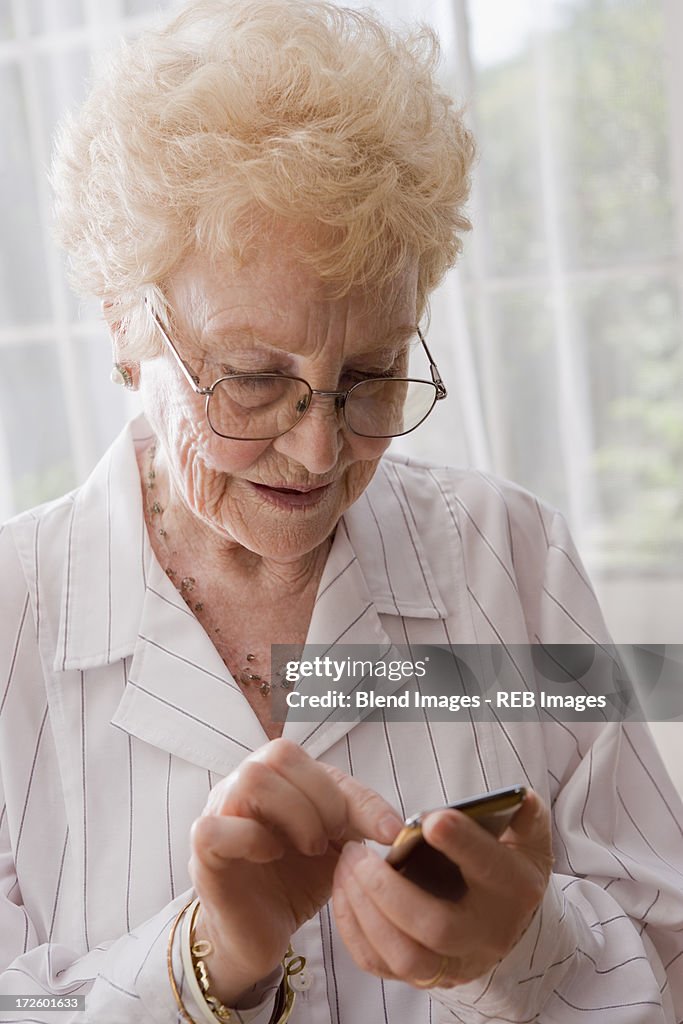 Older Hispanic woman using cell phone