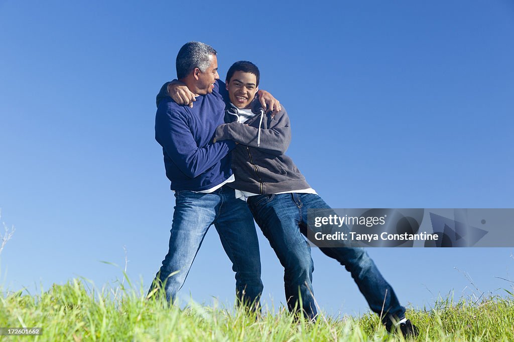 Hispanic father and son playing in park