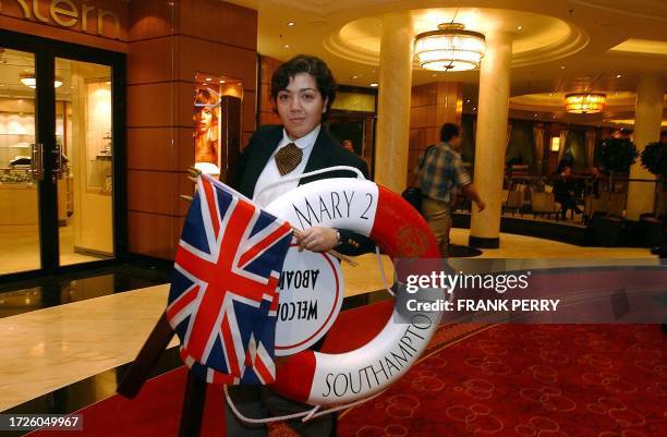 Une employée du paquebot géant Queen Mary 2 procède aux derniers préparatifs, le 10 janvier 2004 à Southampton, à deux jours du départ de la...