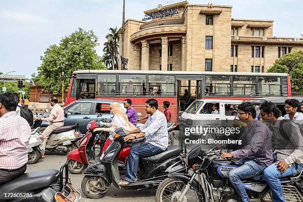 Motorists sit waiting at a traffic signal outside the Reserve Bank of India building in Nagpur, India, on Sunday, June 30, 2013. India's services...