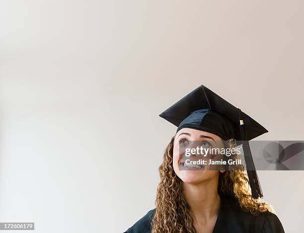 graduate look up in thought - graduation hat stock-fotos und bilder