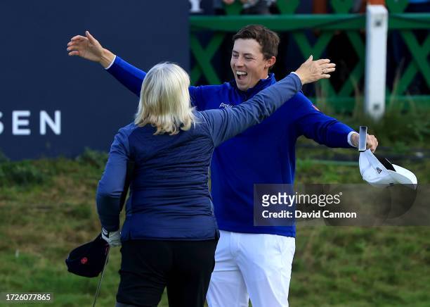 Matthew Fitzpatrick of England embraces his mother Susan Fitzpatrick his amateur playing partrner after he had holed a birdie putt on the18th green...