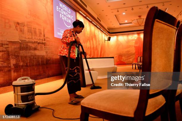 Member of staff sweeps the ground of a meeting room at the World Economic Forum on East Asia..