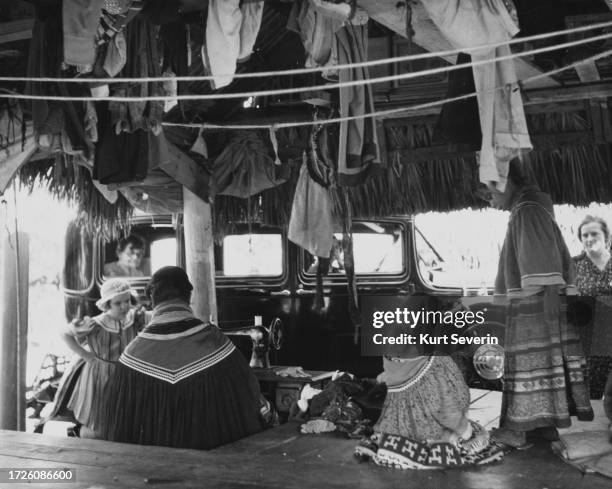 Seminole people selling Native American souvenirs to passing tourists at a roadside shop in the Florida Everglades, Florida, circa 1955.