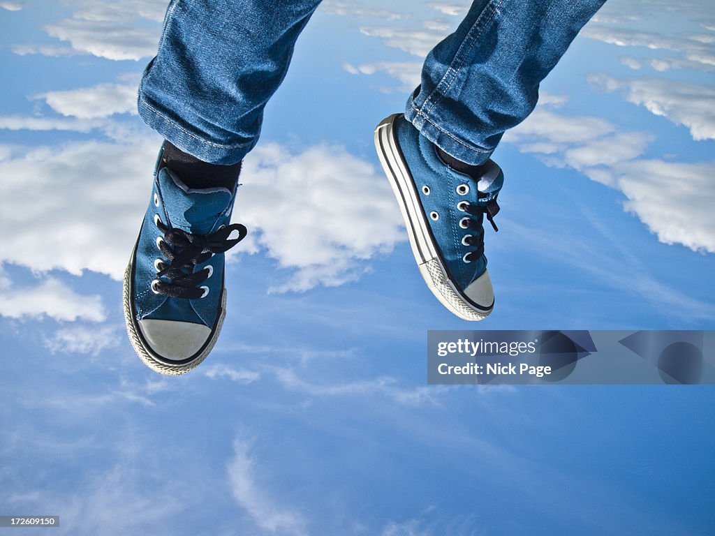 Legs and feet flying against a blue sky