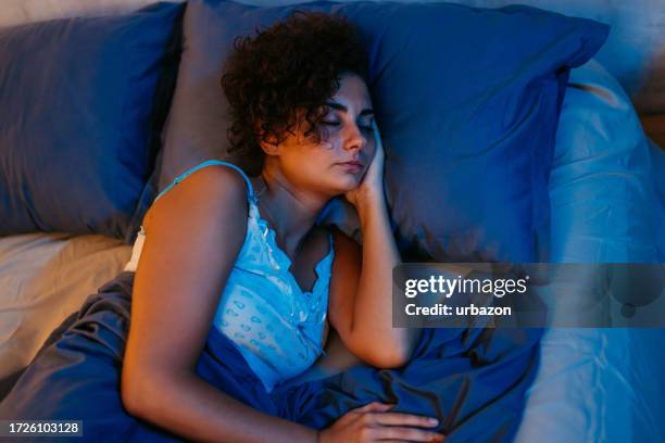 young woman sleeping in the bed at night - overslept stock pictures, royalty-free photos & images