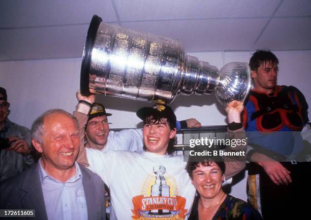 Jaromir Jagr of the Pittsburgh Penguins holds the Stanley Cup with his parents in the locker room after Game 6 of the 1991 Stanley Cup Finals against...