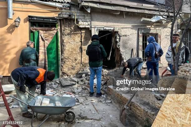 Local residents clean up the rubble in a damaged residential house after shelling on October 9, 2023 in Kherson, Ukraine. The Russian army continues...