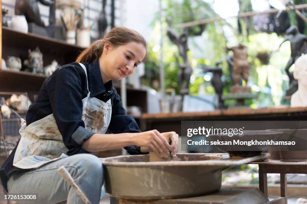 pottery female artist in her studio working on the pottery wheel - woman pottery wheel stock pictures, royalty-free photos & images