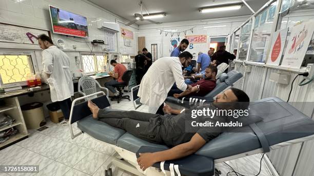 People donate their blood for injured people after the Gaza Minister of Health called for 'urgent blood donations' at Aqsa Hospital in Deir Al-Balah,...