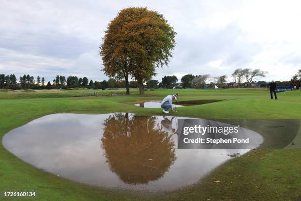 Soren Kjeldsen of Denmark places his ball after losing it in the water on the 10th green during Round Three on Day Five of the Alfred Dunhill Links...