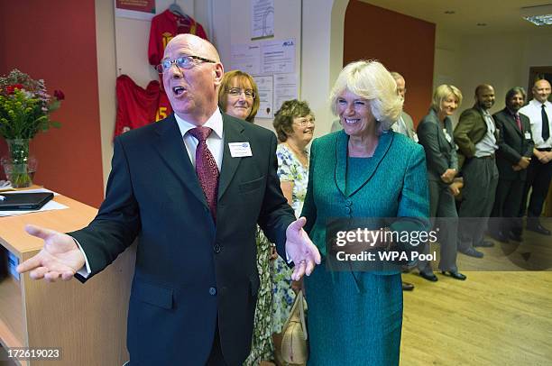 Camilla, Duchess of Cornwall is welcomed by manager Dennis Greenall during her visit to LASA Credit Union on July 4, 2013 in Swansea, Wales. LASA...