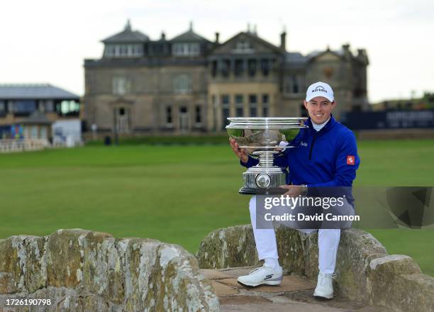 Matthew Fitzpatrick of England poses with the trophy on The Swilcan Bridge after the conclusion of round three on Day Five of the Alfred Dunhill...