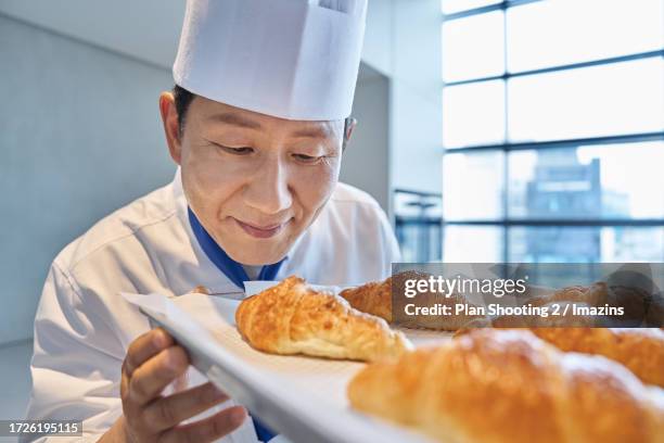 male, 50s, baker, occupation, smile - baker smelling bread stockfoto's en -beelden