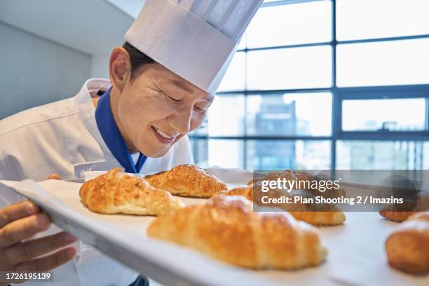 male, 50s, baker, occupation, smile - baker smelling bread stockfoto's en -beelden