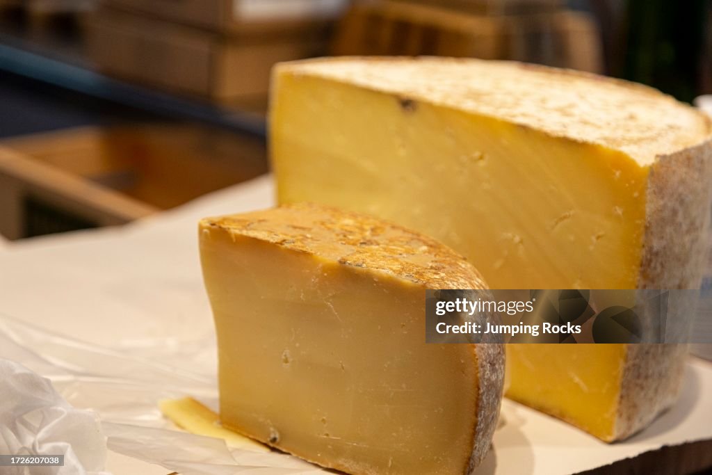 Cheese monger cutting wheel of 7 month aged Cloth Bound Cheddar, Grafton Village Cheese Shop, Grafton, Vermont, USA