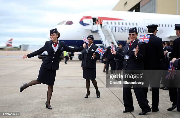 Cabin crew pose for photographs in front of the new Boeing Co. 787 Dreamliner aircraft operated by British Airways at Heathrow airport in London,...