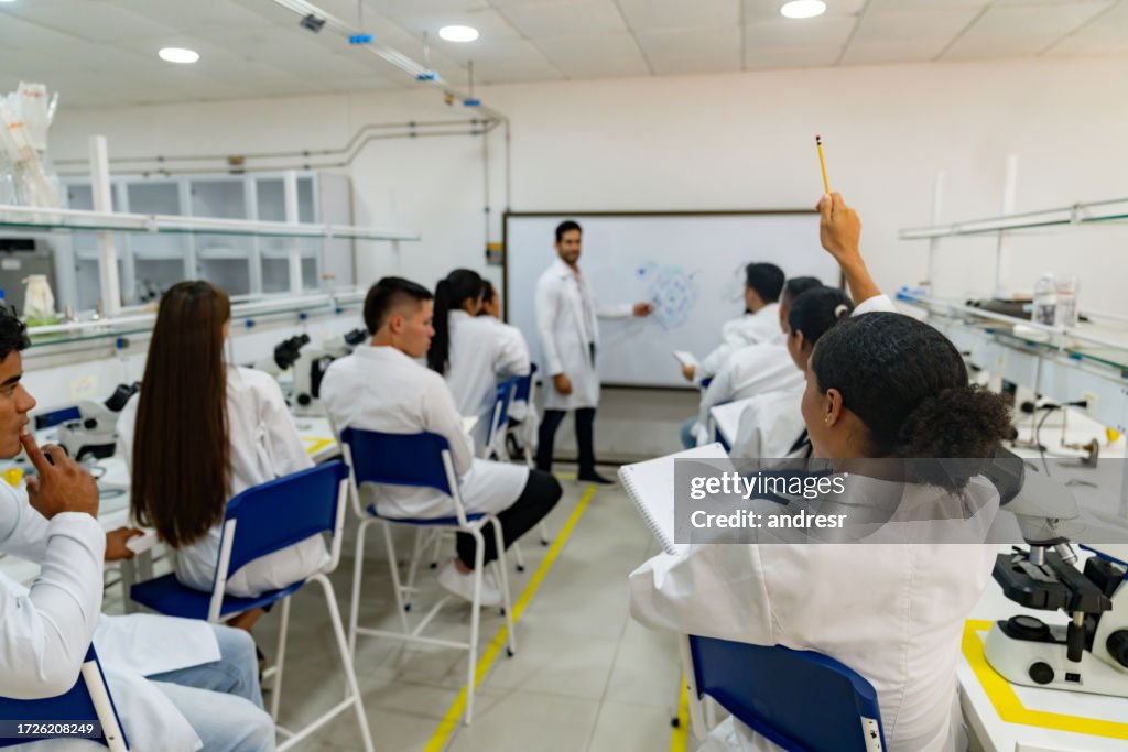 Science student in class asking a question to the teacher