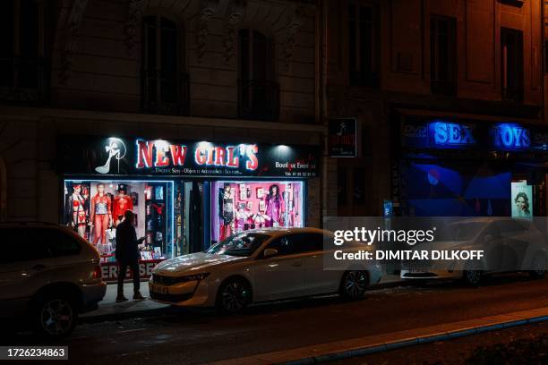 Passerby walks by a sex shop near Place Pigalle at night in Paris on October 13, 2023.