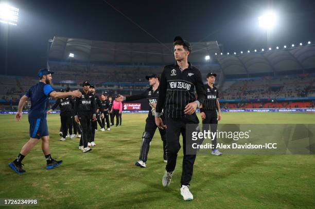Mitchell Santner of New Zealand leads their side off after taking five wickets following the ICC Men's Cricket World Cup India 2023 between New...