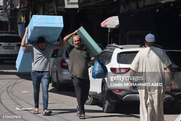 Palestinians carry mattres to displaced from Gaza arrive his house in Rafah refugee camp southern of Gaza Strip , on Octobers 15 2023. Convoys of...