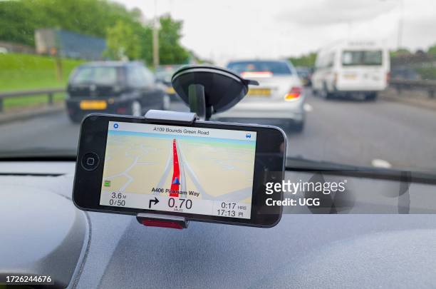 Satnav iPhone app used in a car driving on the A406 North Circular Road, London, UK.