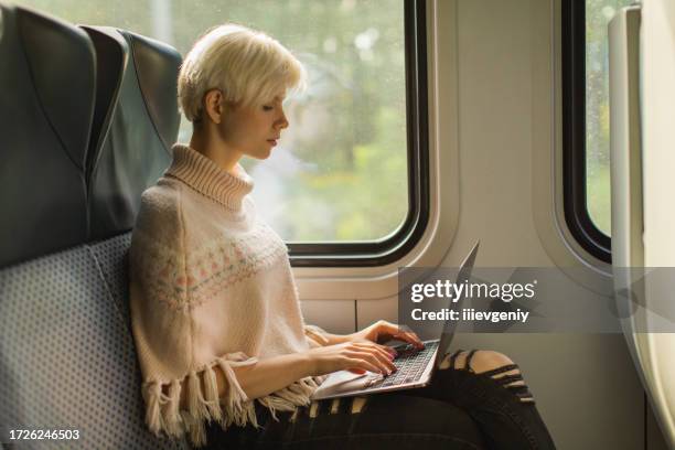 blonde woman using laptop. passenger on train - working on laptop in train top view imagens e fotografias de stock