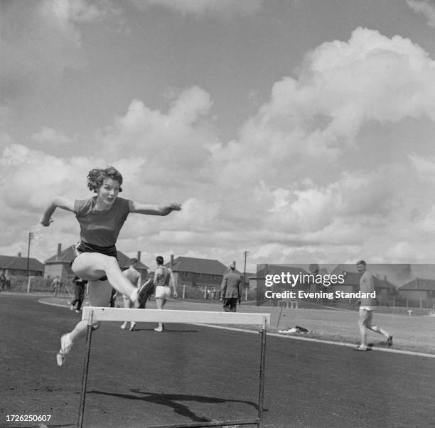 British athlete Carol Quinton jumps a hurdle during training for the British Empire and Commonwealth Games, Cardiff, Wales, July 1958.