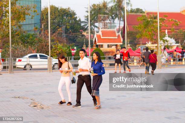 capture candide de jeunes adultes laotiens marchant sur une promenade au bord du mékong à vientiane - all people photos et images de collection