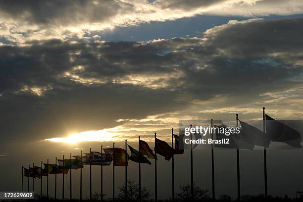 sunset in cloudy sky beyond a row of flags - republic of ireland v oman international friendly stockfoto's en -beelden