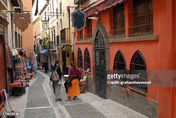 people on walkway between buildings in albaycin, granada - granada españa stock pictures, royalty-free photos & images