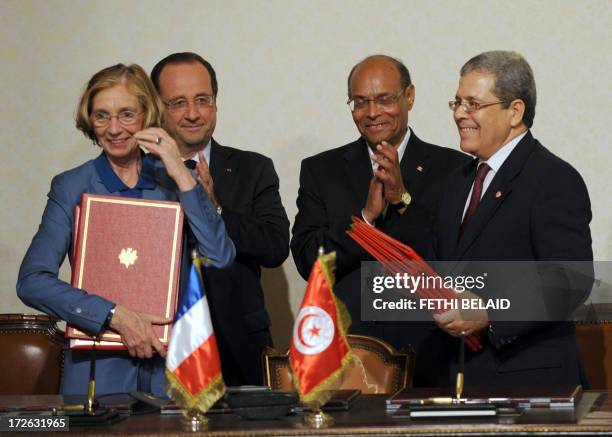 French President Francois Hollande and his Tunisian counterpart Moncef Marzouki clap after French minister for External Trade Nicole Bricq and...