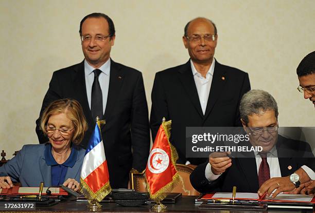 French President Francois Hollande and his Tunisian counterpart Moncef Marzouki clap after French minister for External Trade Nicole Bricq and...