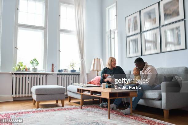 mixed race family spending time together at home - carrying sofa stock pictures, royalty-free photos & images