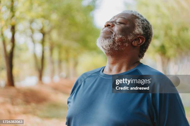 senior man breathing outdoors in public park - inhaling stock pictures, royalty-free photos & images