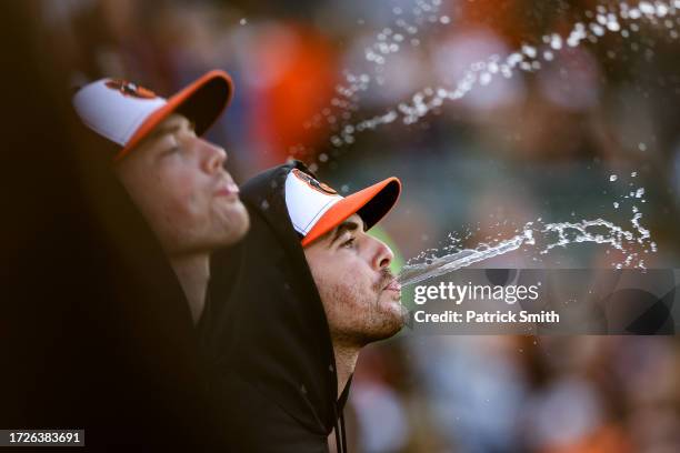 Dean Kremer of the Baltimore Orioles spits water to celebrate a double by Jordan Westburg against the Texas Rangers during the fourth inning in Game...