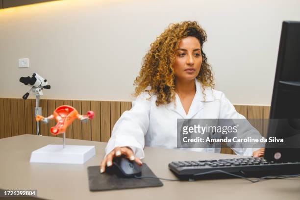 médico ginecologista faz anotações em seu computador - representing - fotografias e filmes do acervo