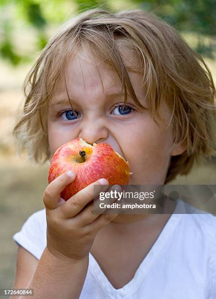 fille mangeant une pomme - pomme croquée photos et images de collection