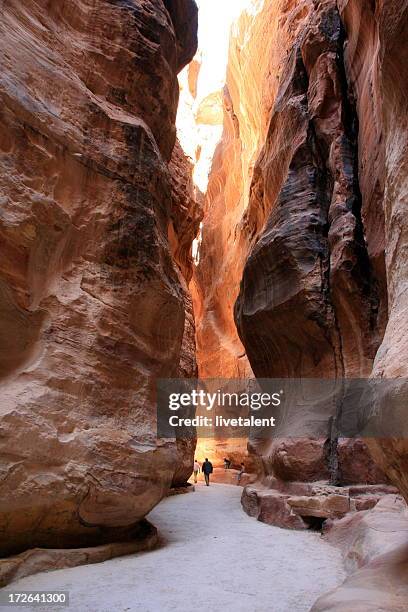 the siq in petra, jordan with tourist walking - petra jordan stock pictures, royalty-free photos & images