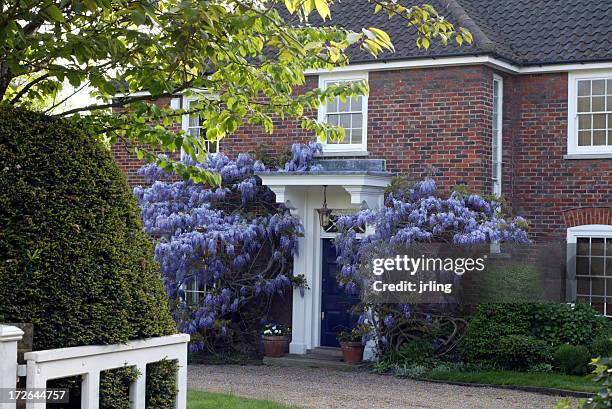 large house with wisteria - blauweregen stockfoto's en -beelden