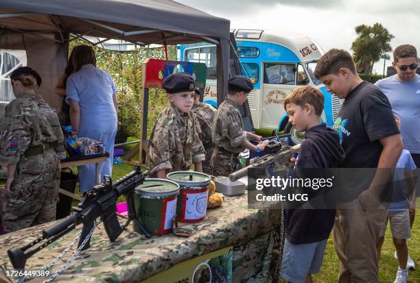 Young Army Cadets in military uniform show other children weapons at a display stand in the military exhibition alongside the annual Eastbourne...