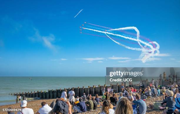 People watch from Eastbourne beach as the world famous RAF display team The Red Arrows fly past the seafront at the annual Eastbourne Airbourne, an...