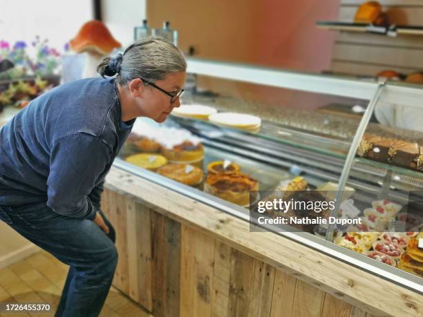 woman in a pastry shop - licking lips stock pictures, royalty-free photos & images