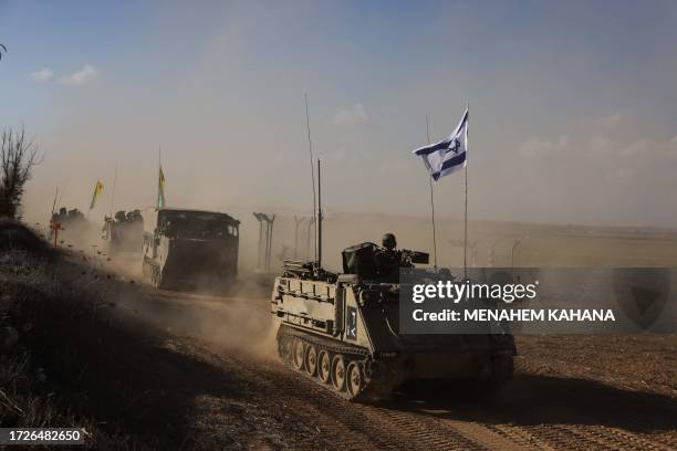 Convoy of Israeli military vehicles drives down a road at an undisclosed location on the border with the Gaza Strip on October 15, 2023. More than...