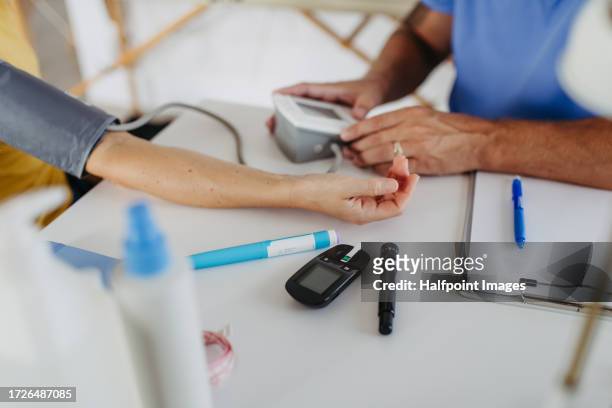 measuring blood pressure at a diabetologist's office. - preventive care stock pictures, royalty-free photos & images
