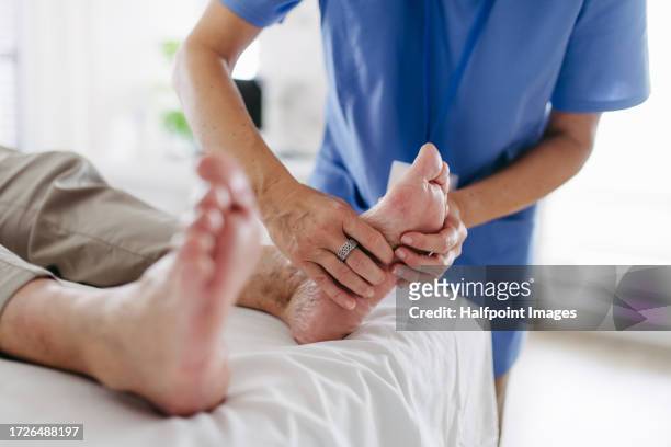 diabetologist testing for loss of sensation in a patient's feet. - neuropathy stockfoto's en -beelden